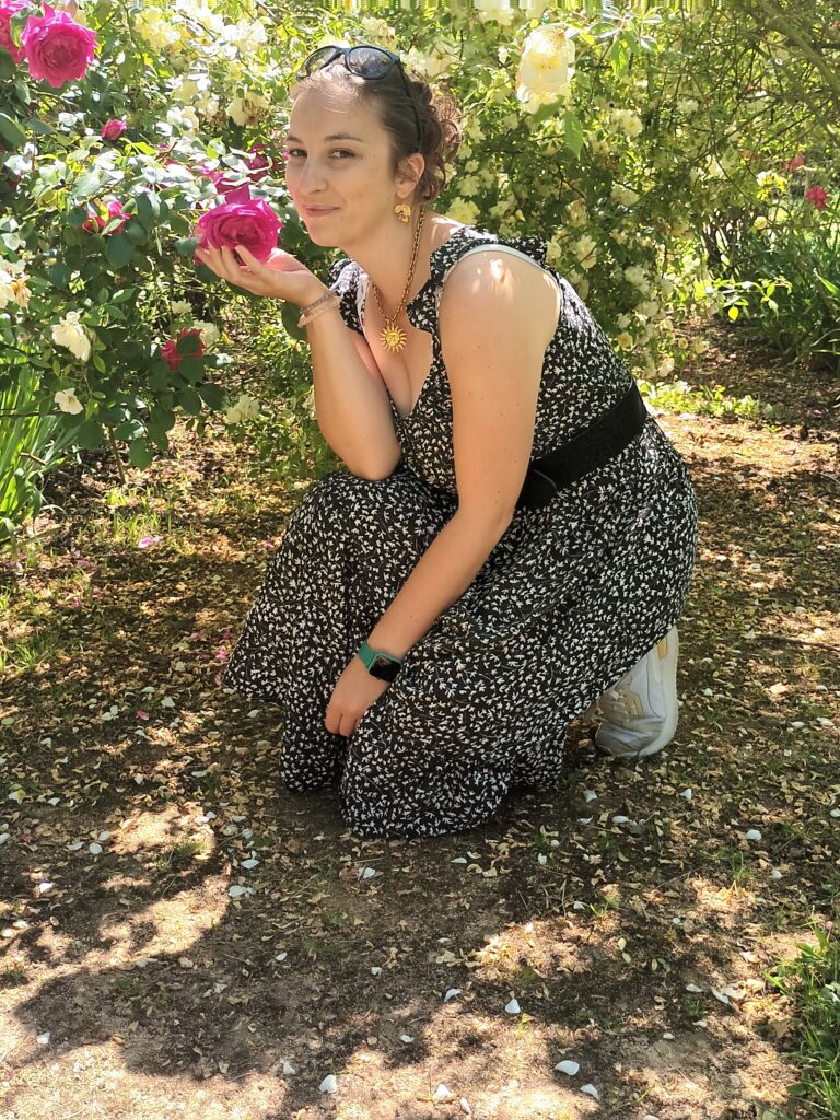 Personne sentant une rose dans la roseraie de Doué-la-Fontaine au printemps en Maine-et-Loire.