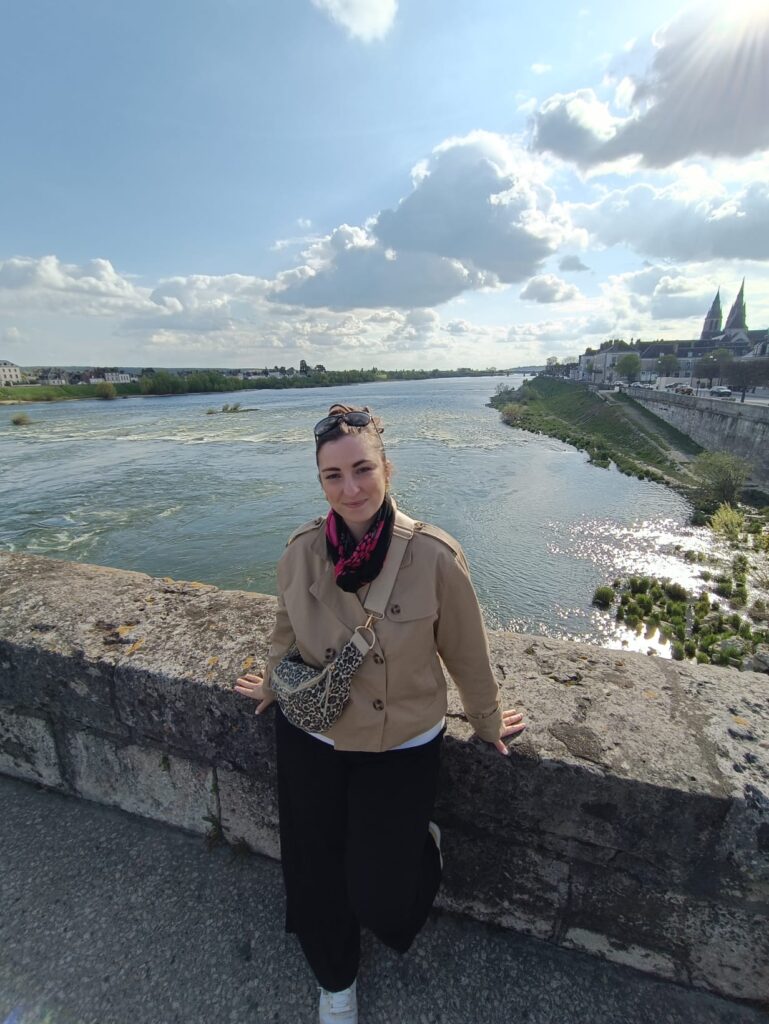Personne sur un pont à Blois avec vue sur la Loire et la ville en arrière-plan.