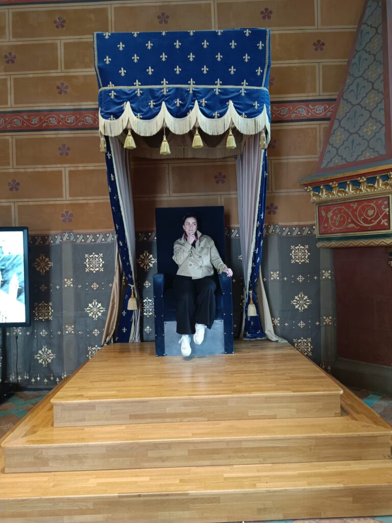 Personne assise sur un trône dans le château royal de Blois lors de la visite.