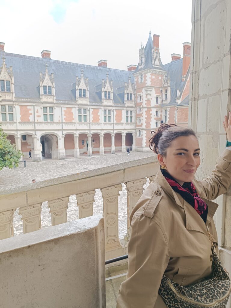 Personne devant le château royal de Blois dans le Loir-et-Cher avec le bâtiment en arrière-plan.