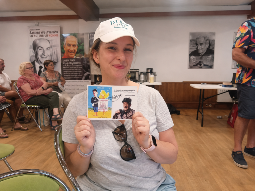 Moi tenant la carte postale dédicacée remportée lors de la tombola de la randonnée « Sur les traces de Louis de Funès » au Cellier.